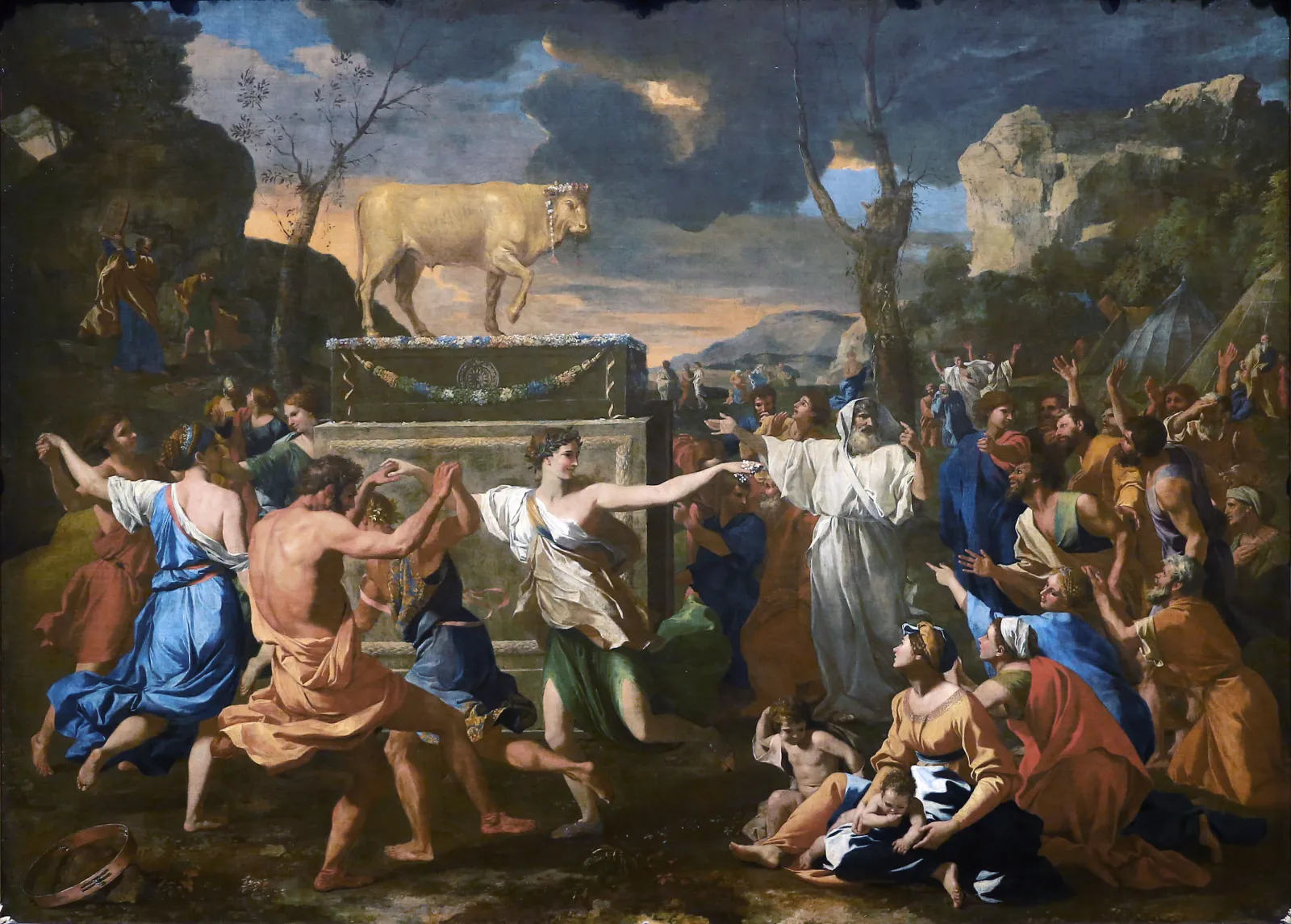 Nicolas Poussinās painting of the golden calf: people dance in a ring around a gold calf on a garlanded pedestal while Aaron, in white, stretches his arms out toward it, and far off in the top left corner Moses comes down the mountain holding up the tablets to smash them